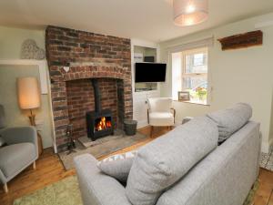 a living room with a couch and a fireplace at The Cottage Bradwell in Bradwell