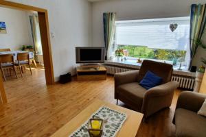 uma sala de estar com um sofá e uma televisão em Haus Minor em Borkum