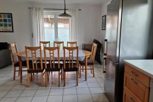 een keuken met een tafel en stoelen en een koelkast bij Huus 24 in Borkum