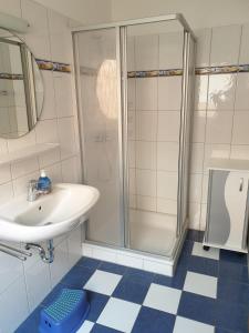 uma casa de banho com um lavatório e um chuveiro em Huus 24 em Borkum