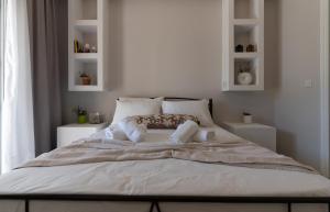 a bed in a white room with white shelves at SkyBlue Horizon Studio 1 in Tsilivi