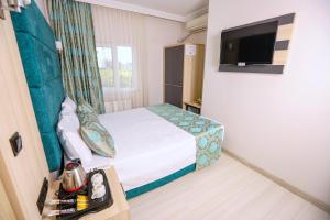 ein Hotelzimmer mit einem Bett und einem Flachbild-TV in der Unterkunft Mare Blu Hotel in Trabzon