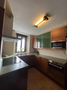 una cucina con armadi in legno, lavandino e forno a microonde di La Perseverancia a Aldehuela