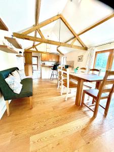 a dining room and living room with a table and chairs at Oak Grange holiday cottage in Hoxne
