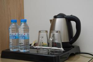 Qabāʼ的住宿－فندق ريست ان，咖啡壶,提供两瓶水和眼镜