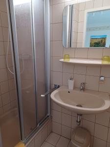 uma casa de banho com um lavatório e um chuveiro em Gästehaus Bausch em Mehring