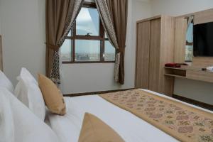 Un dormitorio con una cama grande y una ventana en فندق ريست ان en Qabāʼ