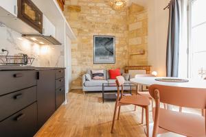 uma cozinha e sala de estar com mesa e cadeiras em Appartements - Bordeaux Centre Gare em Bordeaux