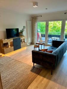 a living room with a couch and a television at Residenz am Pferdemarkt - exklusives Wohnen im Herzen Ostfrieslands - stillvoll & luxuriös in Aurich
