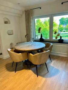 a dining room with a table and chairs and a window at Residenz am Pferdemarkt - exklusives Wohnen im Herzen Ostfrieslands - stillvoll & luxuriös in Aurich