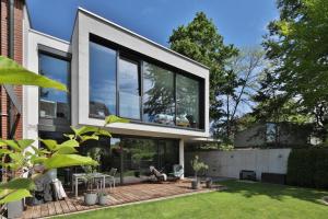 een huis met grote glazen ramen en een patio bij Moderne Studio-Wohnung in Gersthofen