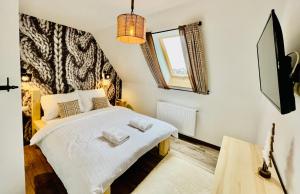 a bedroom with a bed with two towels on it at Luxury Houses & Apartments Zaliński in Zakopane