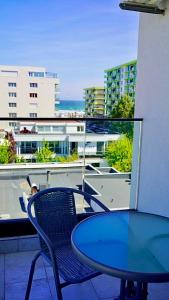 einen Tisch und einen Stuhl auf einem Balkon mit Aussicht in der Unterkunft Mamaia-Nord Boutique Apartments in Mamaia Nord – Năvodari