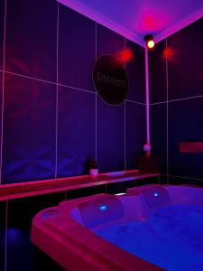 ein lila Zimmer mit Whirlpool. in der Unterkunft L'1TIMISTE in Neuilly-Plaisance