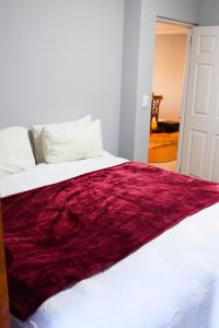 a white bed with a red blanket on it at Waterfront Delight in Knysna