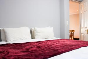 a bed with a red blanket on top of it at Waterfront Delight in Knysna