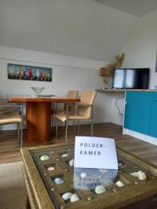a room with a table and a sign that says policekerker at Room by the sea in Zoutelande