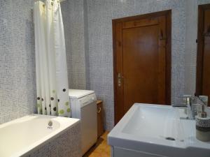 Un baño con bañera, lavabo y ducha. en House with garden, en Sibiu