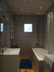 un baño con bañera y lavabo en House with garden, en Sibiu