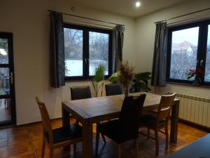 Un comedor con mesa y sillas de madera. en House with garden, en Sibiu