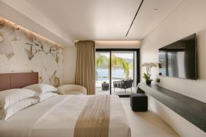 a bedroom with a large bed and a view of the ocean at Casaly Hotel & Spa in Argostoli