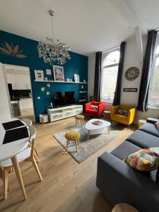 ein Wohnzimmer mit einem Sofa und einem Tisch in der Unterkunft Le National Appartement centre-ville in Tourcoing