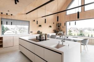 a kitchen with white countertops and large windows at Poczywaj in Jordanów