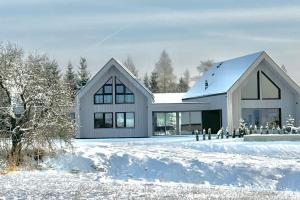 a large white house in the snow at Poczywaj in Jordanów