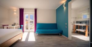 1 dormitorio con 1 cama y 1 sofá azul en l'Oura B&B, en Challand Saint Anselme
