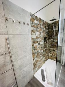 a bathroom with a shower with a stone wall at Prati di Borgo in Rome