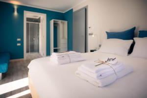 Un dormitorio con una cama blanca con toallas. en l'Oura B&B, en Challand Saint Anselme