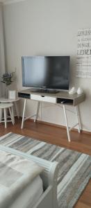 a living room with a flat screen tv on a tv stand at Ferienwohnung Belle Vue in Bernkastel-Kues
