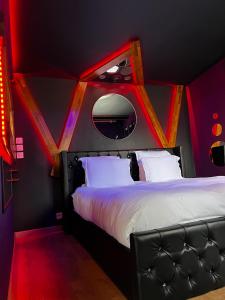 a bedroom with a large bed with a red light at L'1TIMISTE in Neuilly-Plaisance