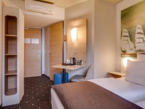 ein Hotelzimmer mit einem Bett und einem Schreibtisch in der Unterkunft B&B Hotel Bremerhaven in Bremerhaven