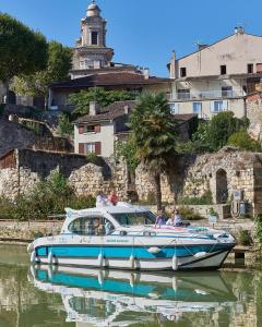 a blue and white boat in the water with people on it at Lavardac - Maison de Village Gascogne Landes in Lavardac