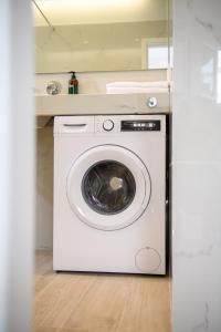 a washer and dryer in a white laundry room at Olivia’s House in Kavos