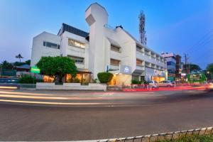 a building on a city street with streaks of traffic at Abad Fort in Cochin