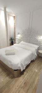 a bedroom with a large bed with white sheets at Hermosos Apartamentos en pleno Centro in Granada