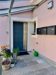 ein blaues Garagentor auf einem rosa Haus mit Pflanzen in der Unterkunft Ferienwohnungen zur POST 2 in Breitenbrunn
