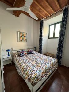 a bedroom with a bed and a ceiling fan at Le petit refuge in Capraia