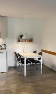 a dining room with a white table and chairs at Skipalaekur Farm Apartments in Egilsstaðir