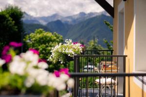 a balcony with a table and chairs and flowers at l'Oura B&B in Challand Saint Anselme +11 photos