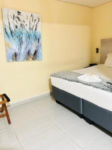 una camera da letto con un letto e un dipinto sul muro di THE GALAXY FOREST LODGE a Manguzi