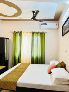 Anandmay Homestay, ISBT Rishikesh في ريشيكيش: غرفة نوم بسرير مع ستائر خضراء