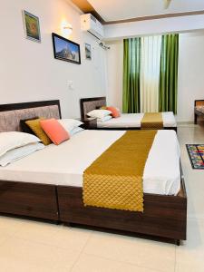 Anandmay Homestay, ISBT Rishikesh في ريشيكيش: سريرين في غرفة فندق مع