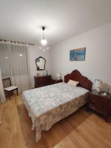 a bedroom with a bed and two tables and a mirror at PONTECESO, MAR Y FER in Ponteceso