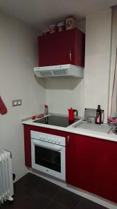 a red kitchen with a sink and a stove at PONTECESO, MAR Y FER in Ponteceso