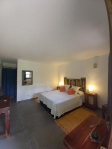 Schlafzimmer mit einem weißen Bett und einem Spiegel in der Unterkunft Veiga Mariña in A Xesteira