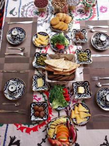 stół z dużą ilością talerzy żywności w obiekcie Khiva Amir Tora B&B w mieście Chiwa