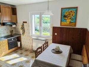 a kitchen with a dining room table and a window at Apartma ZORA in Pobegi